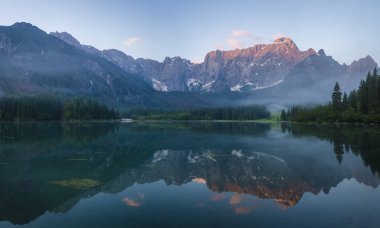 Julian Alps için kristal berraklığında dağ Gölü üzerinde gündoğumu