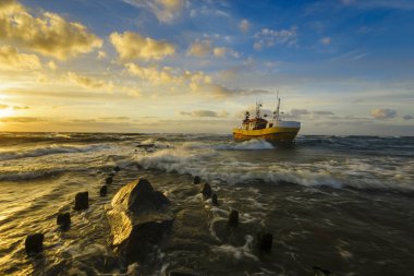 Denizde bir fırtına sırasında dalgaları ile mücadele balıkçı teknesi