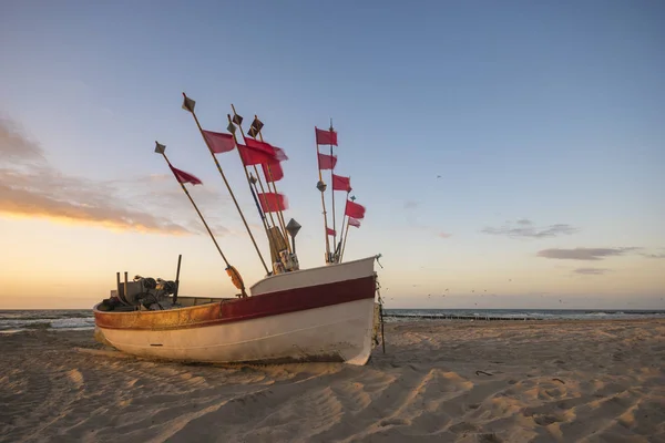 Pôr do sol sobre o mar, barco de pesca na praia — Fotografia de Stock