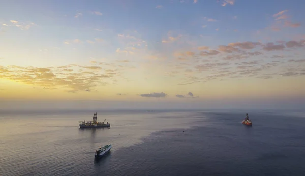 Drilling platforms in the ocean at sunrise, view from the air