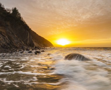a spectacular, dynamic sunset around the cliffs in Wolin national park in Poland clipart