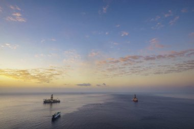 Okyanusta platformlar güneş doğarken delme, havadan görüntüleme