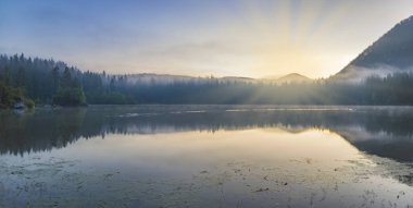 Julian Alps için kristal berraklığında dağ Gölü üzerinde gündoğumu