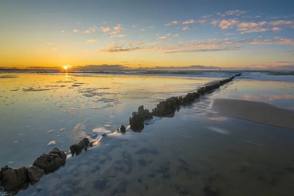 Балтійське море на гарний схід сонця, дерев'яні breakwater легка продо — стокове фото