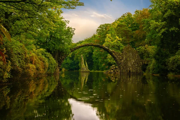 Herbst, bewölkter Abend über der Teufelsbrücke im Park Kromlau, — Stockfoto