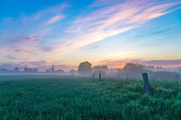 Dimmig morgon i fältet nära byn — Stockfoto