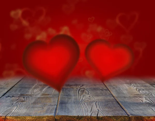 Czerwone serca na drewnianym stole przeciwko rozmycie światła — Zdjęcie stockowe