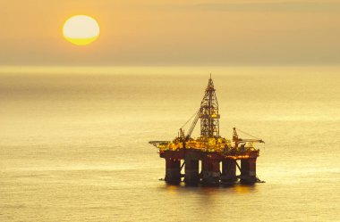güneş doğarken sondaj platformu denizde