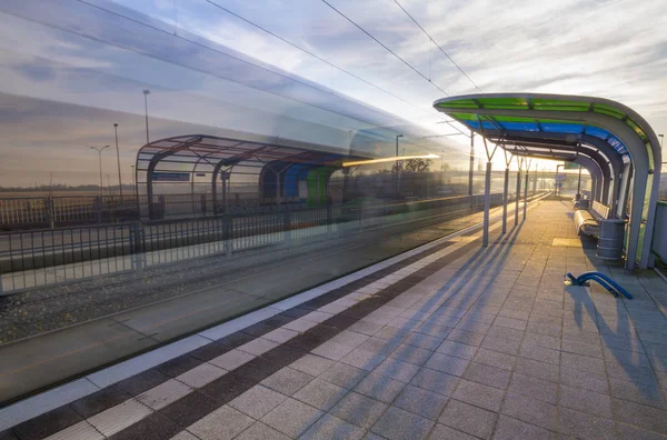 a modern tram stop, blurred silhouette of a passing tram