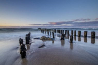 gün batımında dalgalar breaking bir deniz dalgakıran