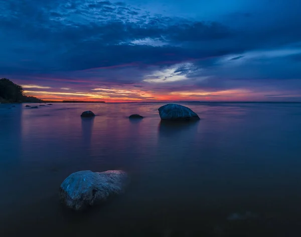 Πύρινο ηλιοβασίλεμα πάνω από τον γκρεμό στη θάλασσα — Φωτογραφία Αρχείου
