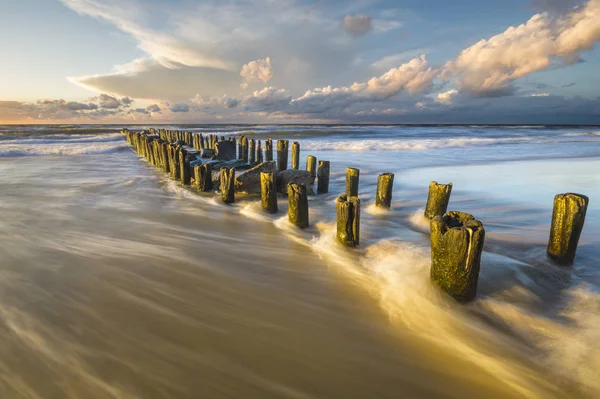 A tenger hullámtörő törés a hullámok a naplemente — Stock Fotó