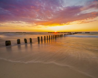 dalgalar deniz kumlu sahilde günbatımı sırasında Baltık Denizi üzerinde