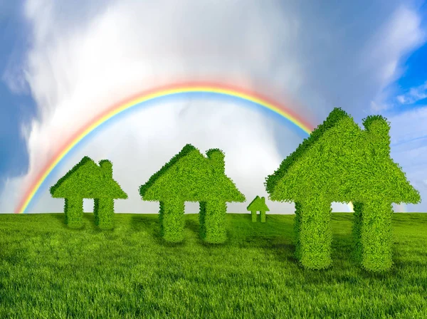 concept of green, ecological houses on a green meadow against the blue sky