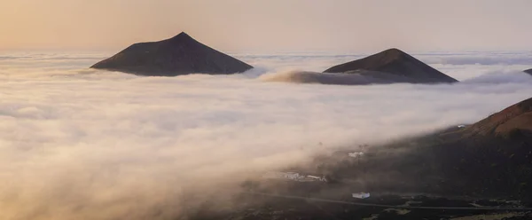 Picos vulcânicos acima das nuvens durante um belo nascer do sol.Lanzarote — Fotografia de Stock