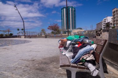 şehirde evsizler tarafından bankta bırakılan giysi ve şeyler