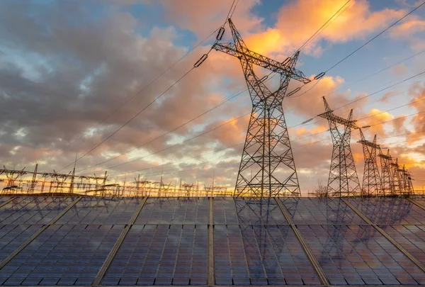 Gün batımında elektrik direci ile güneş panelleri. Temiz enerji con — Stok fotoğraf