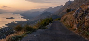 La üzerinde bir uçurumun kenarında çalışan dar, dolambaçlı bir yol