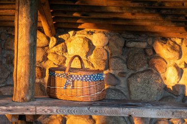 Tahta bir masanın üzerinde, duvarın arkasında duran sepet.