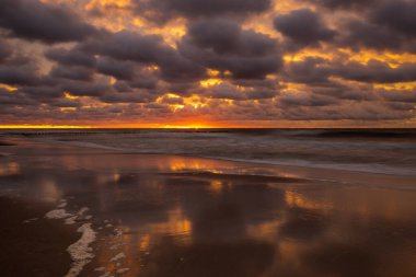Gün batımında deniz manzarası. Kumsal, deniz dalgaları, dalgalar.