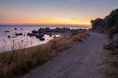 Güneş doğarken Ege Denizi üzerindeki toprak yol