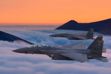 Boeing F-15E Vurucu Kartal pozisyonu bulutların üzerinde uçuyor.