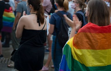 LGBT eşitlik yürüyüşü, haklar için mücadele. Gökkuşağı kıyafeti giyen gençler LGBTQ + hakları için mücadele ediyorlar. Koronavirüs salgını sırasında gösteri. Gökkuşağı bayrakları, bayraklar.