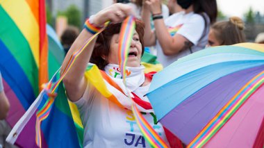 KATOWICE / Polonya - 10 Ağustos 2020: LGBT eşitlik yürüyüşü. Gökkuşağı kıyafeti giyen gençler LGBTQ + hakları için mücadele ediyorlar. Koronavirüs salgını sırasında gösteri. Gökkuşağı bayrakları, bayraklar.