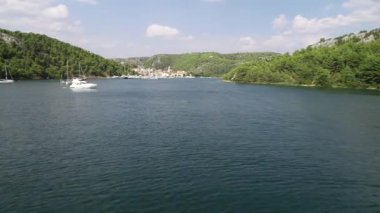 Beyaz yelkenlilerin ve yatların havadan görüntüsü turkuaz ve suyla marinaya yüklendi. Hırvatistan, Avrupa. Fransa, İtalya, Monako, Yunanistan ve İbiza 'da su sporları ve yat haftası. Akdeniz manzarası