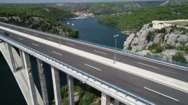 Hırvatistan, Avrupa 'daki Krka nehri üzerindeki ünlü köprünün hava manzarası. Arka planda güzel Akdeniz yeşil manzarası ve yatları.