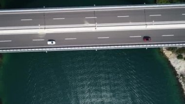 Hırvatistan, Avrupa 'daki Krka nehri üzerinde trafiği olan otostrada köprüsünün hava görüntüsü. Arka planda güzel Akdeniz yeşil manzarası ve yatları.