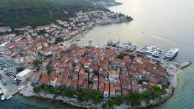 Hırvatistan 'ın Korcula adasının hava manzarası, gün batımında veya gün doğumunda. Kuleleri, marinası, limanı, büyük lüks yatları ve yelkenlileri olan eski bir şehir. Yaz mevsiminde Akdeniz kenti.