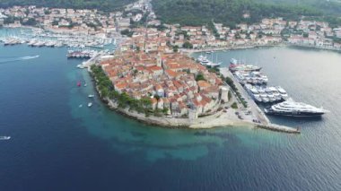 Hırvatistan 'ın Korcula adasının hava manzarası, gün batımında veya gün doğumunda. Kuleleri, marinası, limanı, büyük lüks yatları ve yelkenlileri olan eski bir şehir. Yaz mevsiminde Akdeniz kenti.