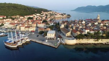 Hırvatistan 'ın Korcula adasının hava manzarası, gün batımında veya gün doğumunda. Kuleleri, marinası, limanı, büyük lüks yatları ve yelkenlileri olan eski bir şehir. Yaz mevsiminde Akdeniz kenti.