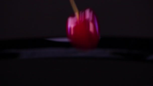 樱桃飞溅入水中 美味的樱桃落在黑色的背景上 落在黑色的水面上 水果的电影镜头 食品商业 — 图库视频影像