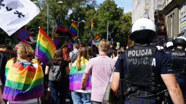 KATOWICE / Polonya - 7 Eylül 2020: LGBT eşitlik yürüyüşü. Gökkuşağı kıyafeti giyen gençler LGBTQ + hakları için mücadele ediyorlar. Polis koronavirüs salgını sırasında gösteriyi kordon altına aldı. 