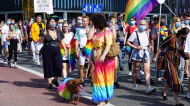 KATOWICE / Polonya - 7 Eylül 2020: LGBT eşitlik yürüyüşü. Gökkuşağı kıyafeti giyen gençler LGBTQ + hakları için mücadele ediyorlar. Koronavirüs salgını sırasında gösteri. Gökkuşağı bayrakları, bayraklar.