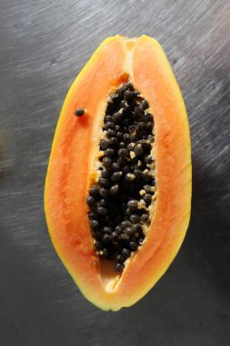 Mutfak masasında yarım papaya meyvesi..