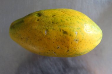 Papaya meyvesi mutfak masasında. Gri metal arkaplan.