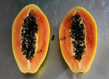 Mutfak masasında iki parça papaya meyvesi..
