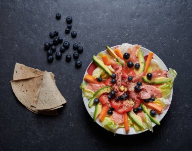 Tütsülenmiş somon salatası, taze sebze, yabanmersini ve tohum, avokado, havuç, buz salatası, domates, zencefil, susam tohumu, keten tohumu ve goji üzümü.