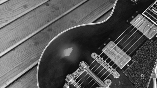 Electric guitar on the wooden boards with copy space . Black and white