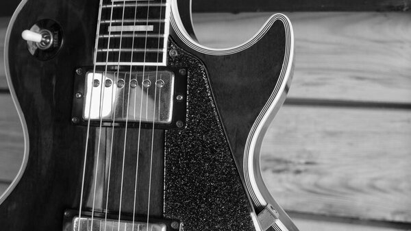 Electric guitar on the wooden boards . Black and white