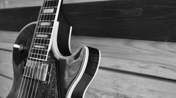 Electric guitar on the wooden boards . Black and white