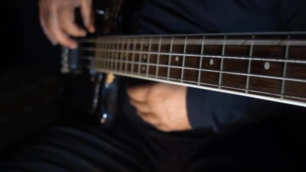Musiker Spielt Bassgitarre Dunkler Hintergrund Nahaufnahme — Stockvideo