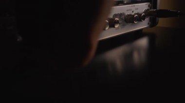 Enstrümantal bir gitar amfisini açmak ve sesi ayarlamak: Yakın plan