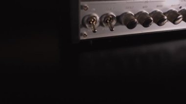 Enstrümantal bir gitar amfisini açmak ve sesi ayarlamak: Yakın plan