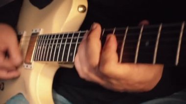 Stüdyoda beyaz gitar çalan müzisyen.