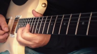 Stüdyoda beyaz gitar çalan müzisyen.