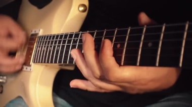 Stüdyoda beyaz gitar çalan müzisyen.